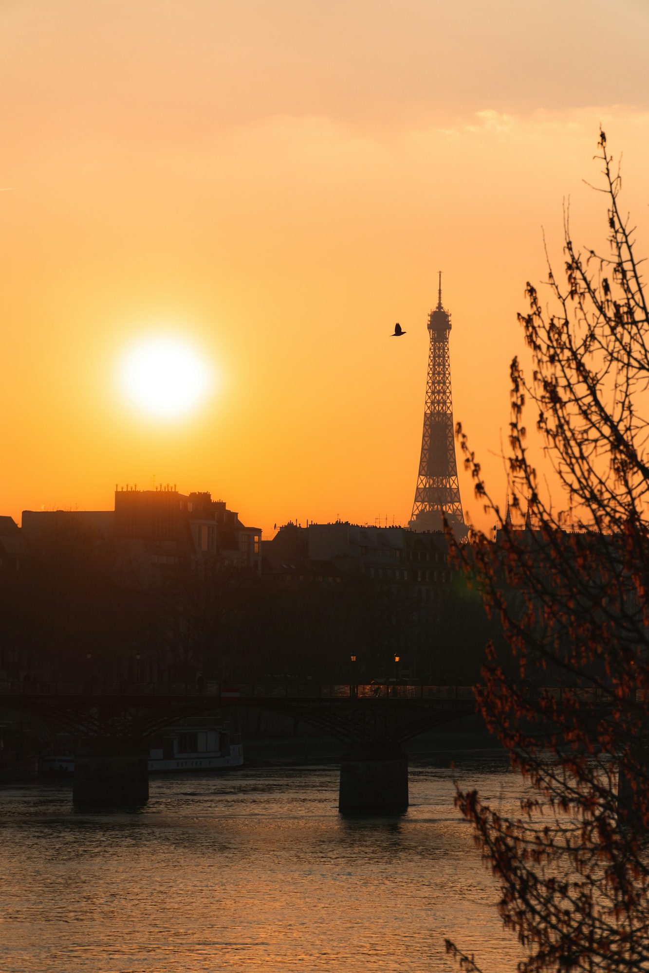The Eiffel Tower silhouetted at sunset across the Seine River, Paris